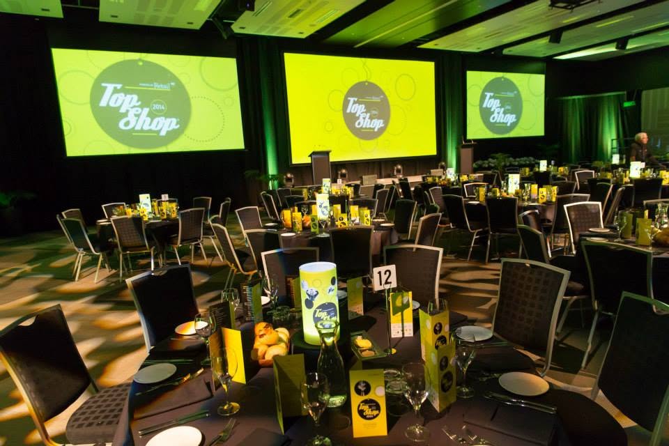 Top Shop awards dinner room set with branded stage screens